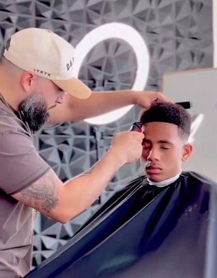 a barber finishing a fade haircut in his Lewisville salon suite.