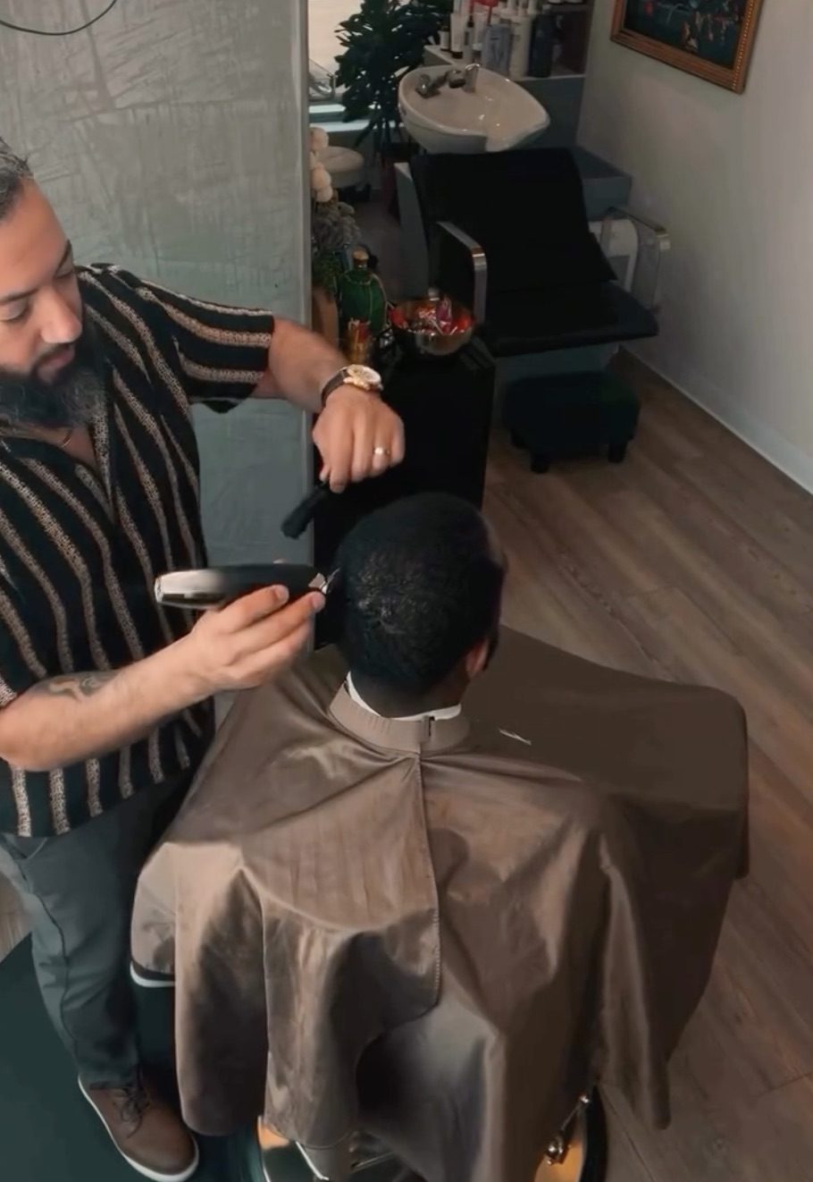 Barber giving a client a clipper cut in his private salon suite in Fort Worth, filling an open slot from his standby list